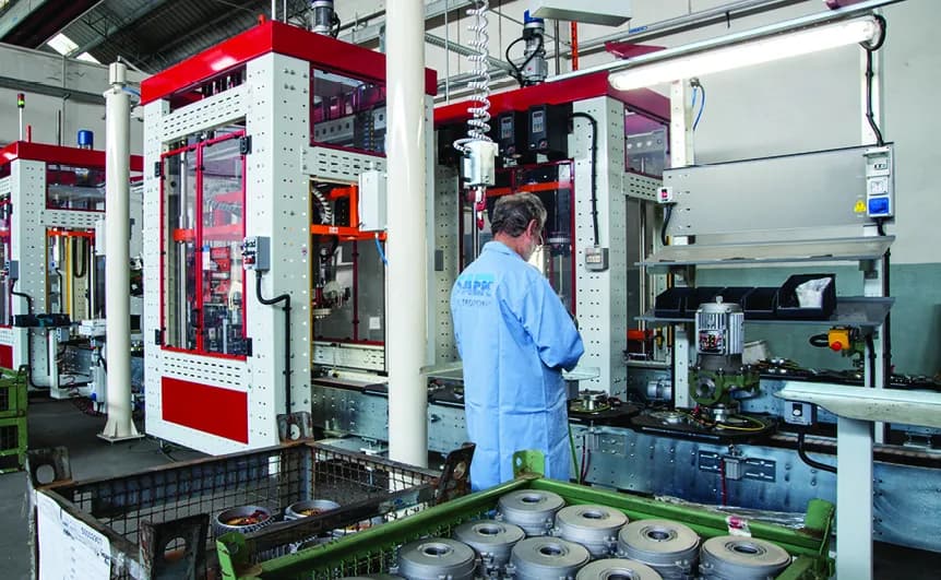 SAER Elettropompe factory floor with a worker operating machinery, showcasing the manufacturing process in Italy.