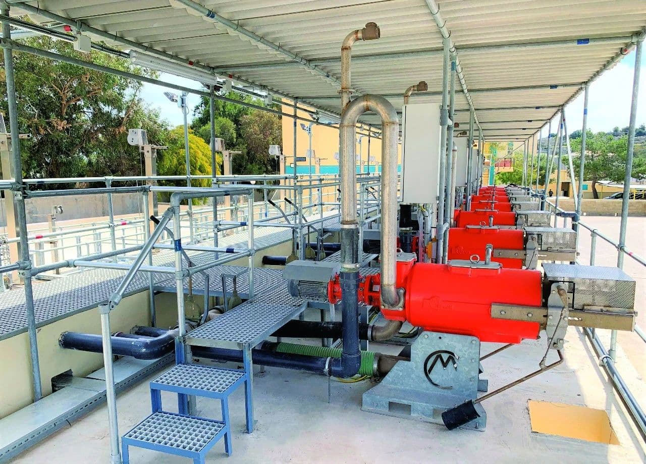 A row of powerful CRI-MAN industrial water treatment pumps, in a covered outdoor facility. The orange pumps are
arranged along a walkway, highlighting a large-scale, organized water processing system.