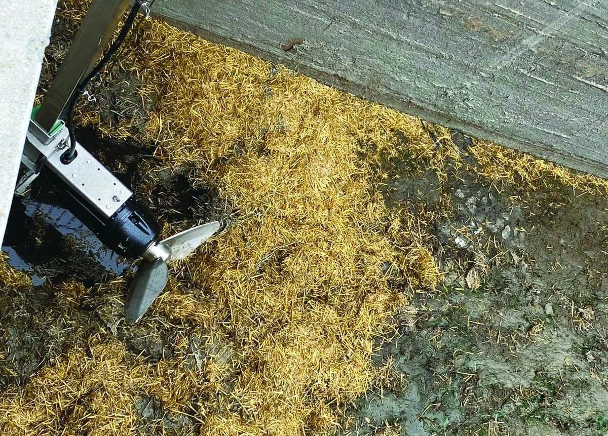 A CRI-MAN submersible mixer with its propeller partially submerged in a thick mixture of what appears to
be agricultural waste or slurry. This demonstrates the mixer's capability to handle dense and challenging materials.